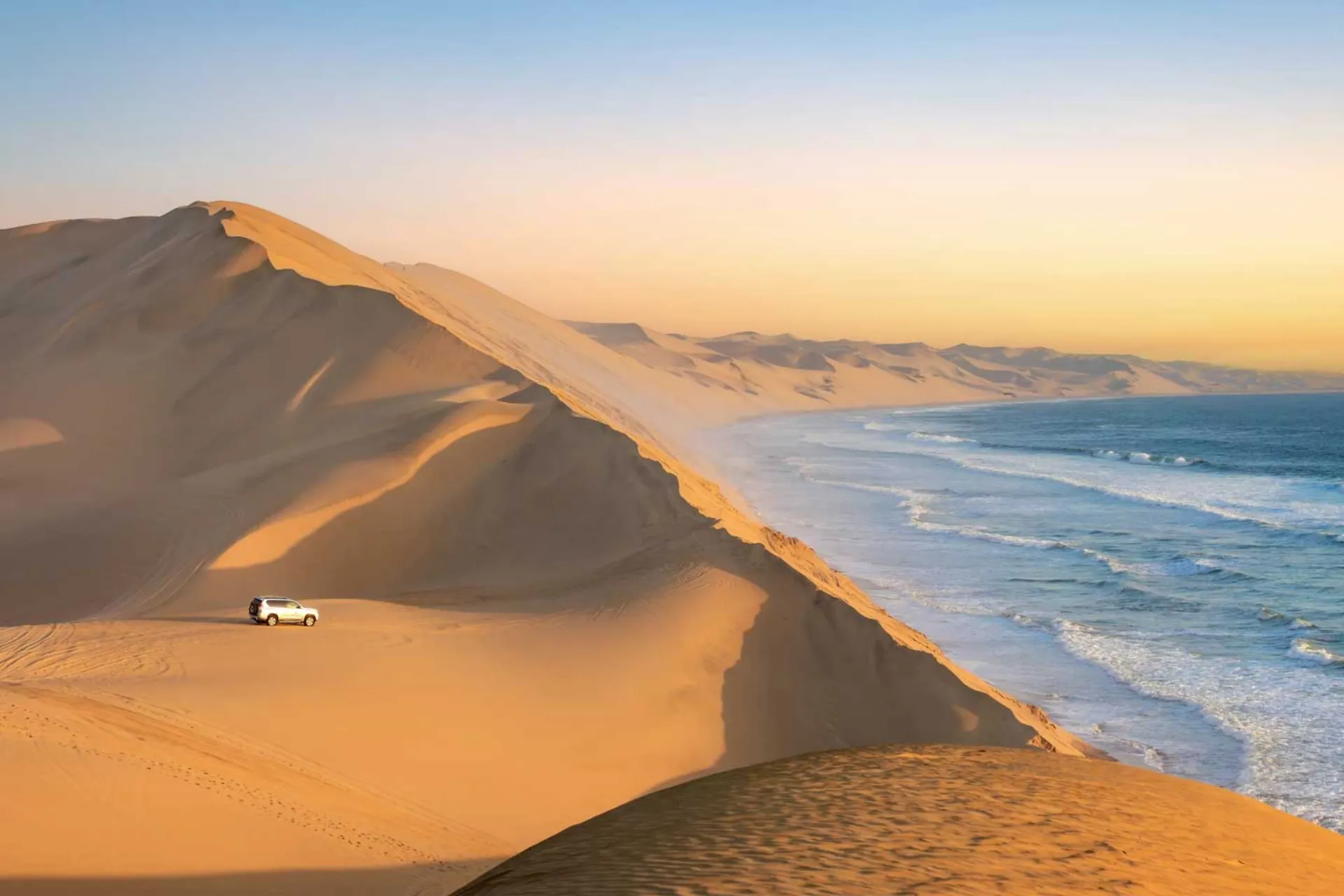 Sandwich Harbour i Namibia, där de höga sanddynerna sluttar direkt ner i havet Sandwich Harbour i Namibia, där de höga sanddynerna sluttar direkt ner i havet